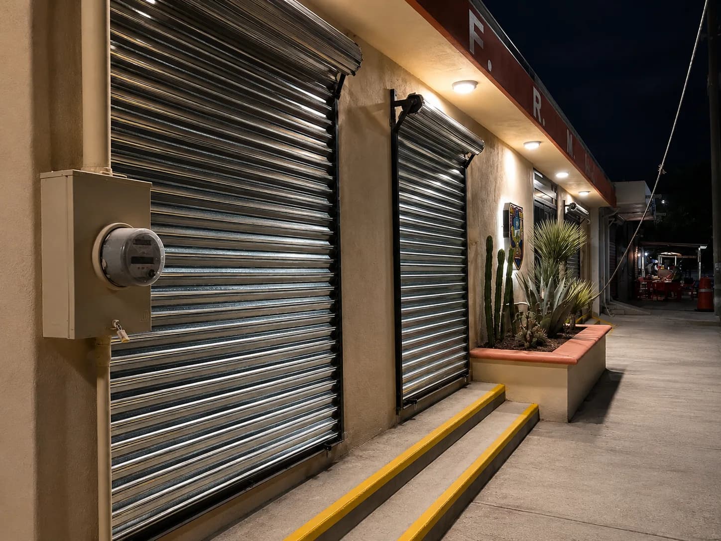 Fachada de locales comerciales terminada, vista nocturna con rampa señalizada